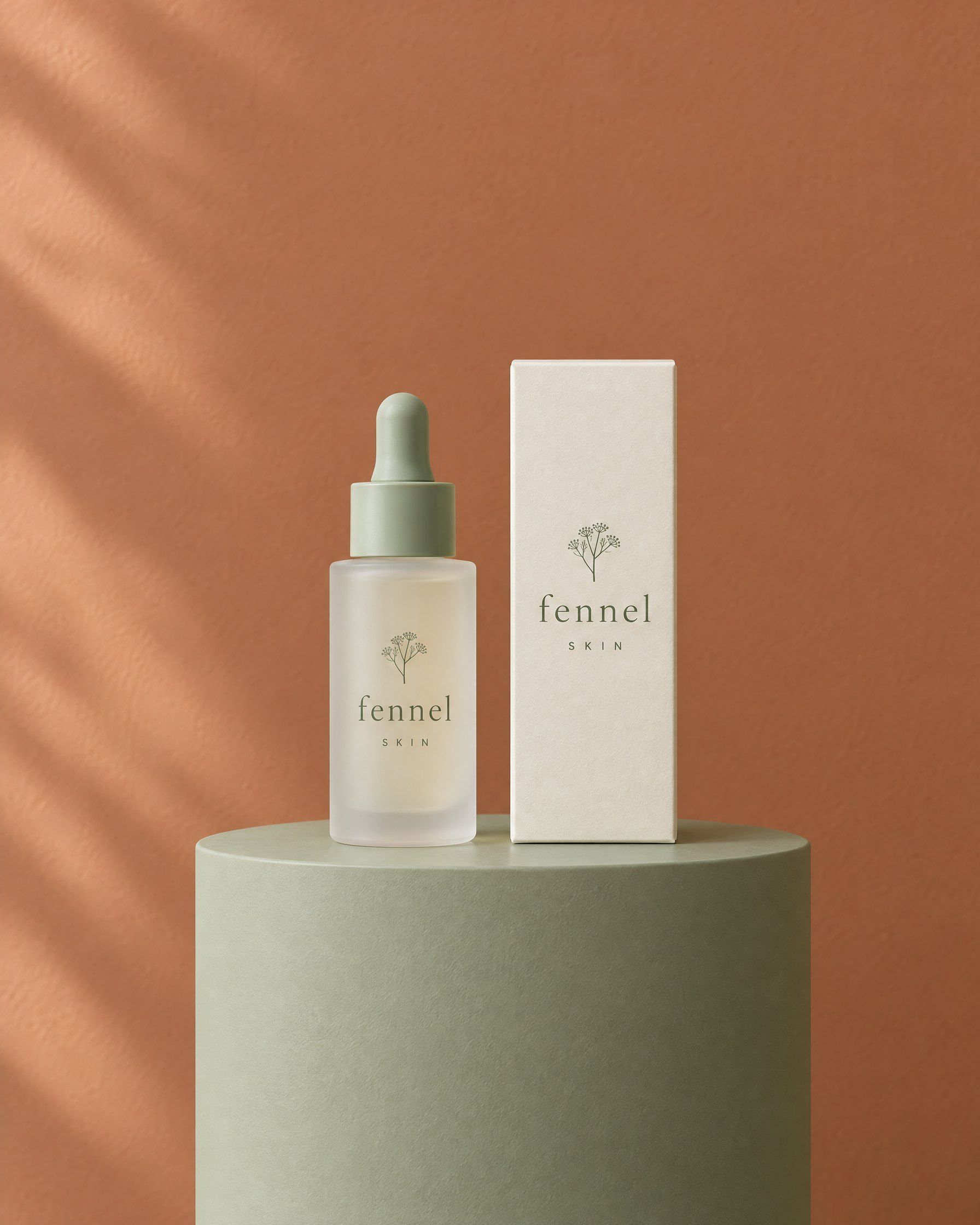 A frosted Fennel Skin serum bottle and its cream box on a sage plinth against a warm clay wall.